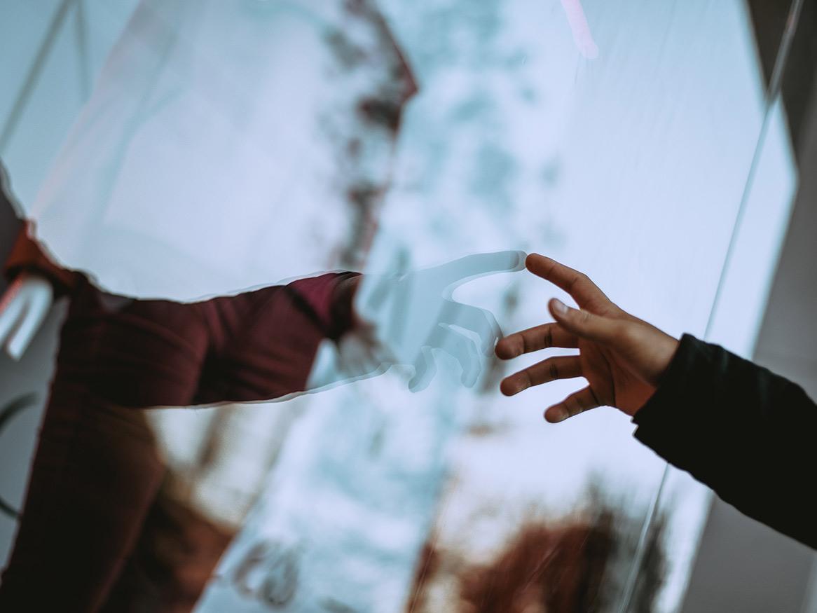 Arm pointing, reflection in a window