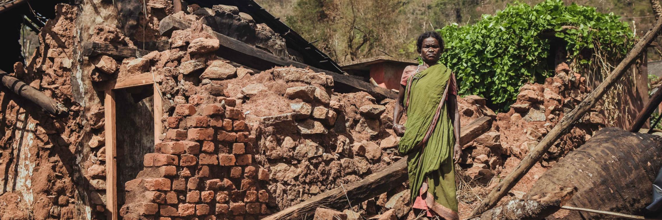 Woman standing by house ruins