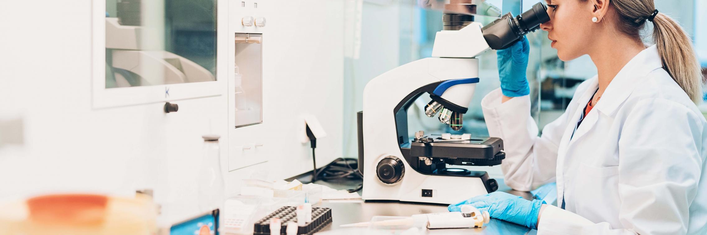 Scientist looking into microscope