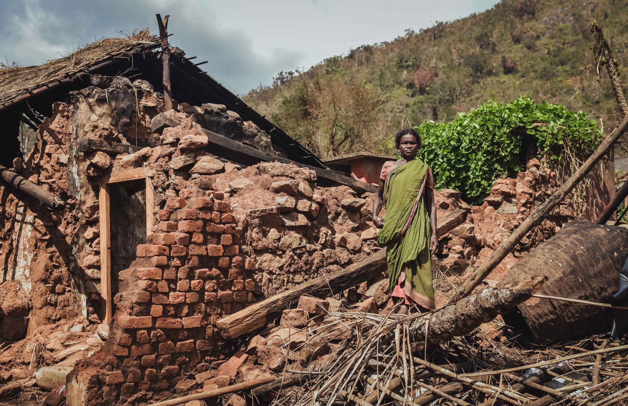 Woman standing by house ruins