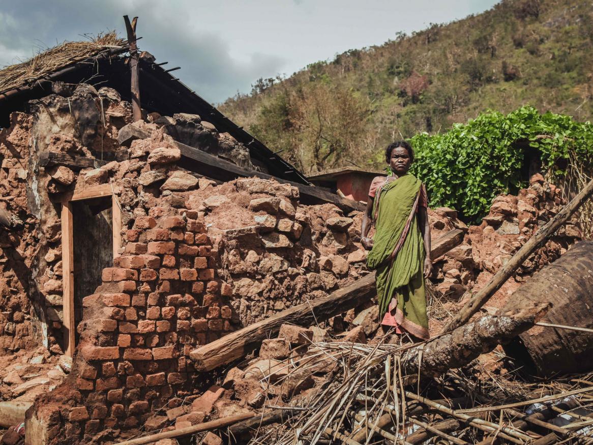 Woman standing by house ruins