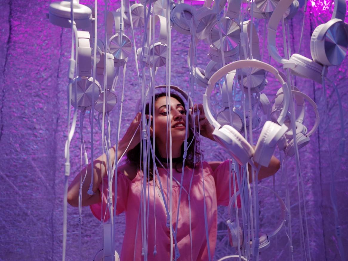 Woman standing in music installation with headphones