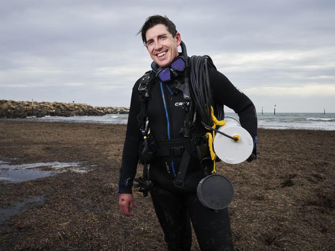 Dr Dominic McAffee holding a music speaker