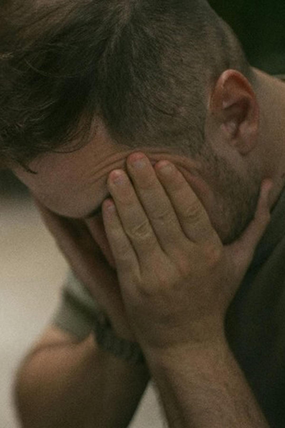 A man holding his face in his hands in distress