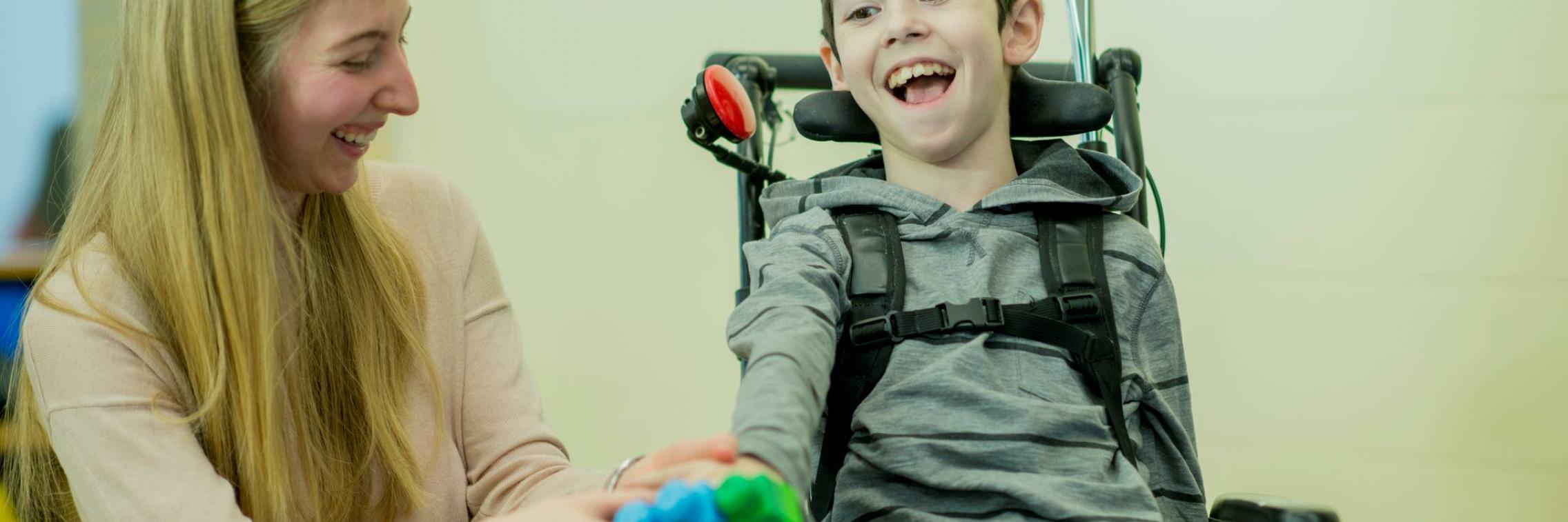 Women and a boy with cerebral palsy interacting