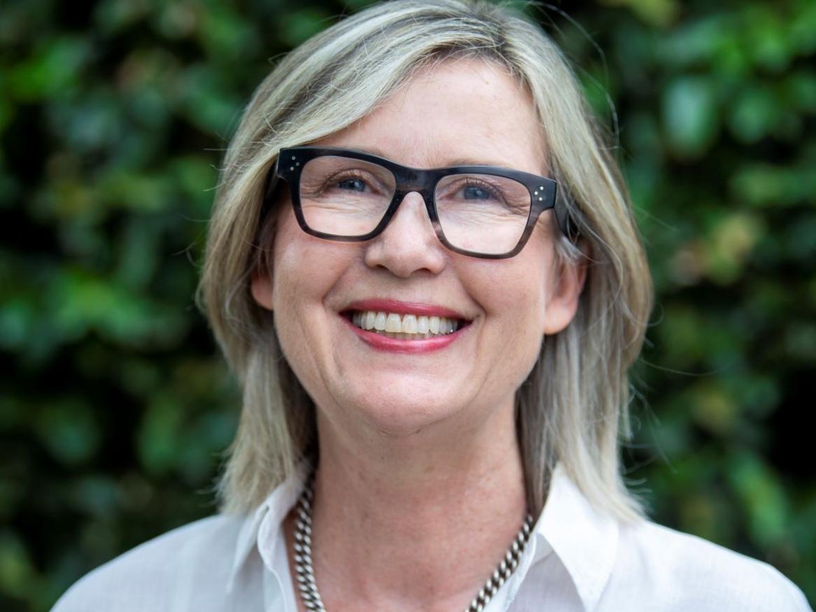 Female researcher with glasses and white shirt