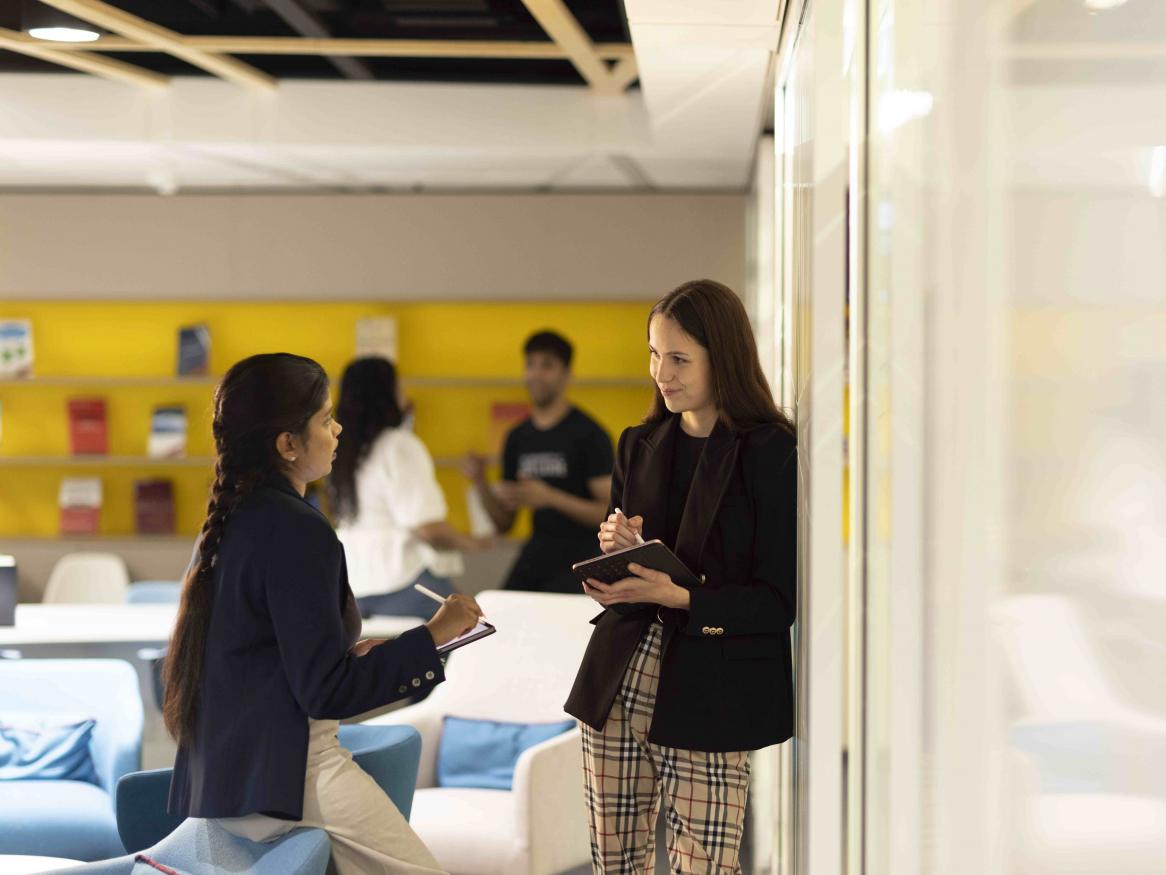 Student and teacher speak in MBA lounge