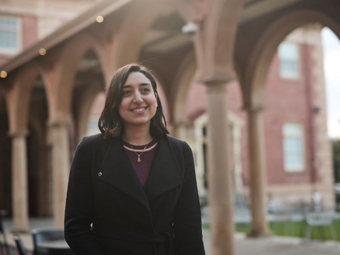 Woman smiling outside the University cloisters