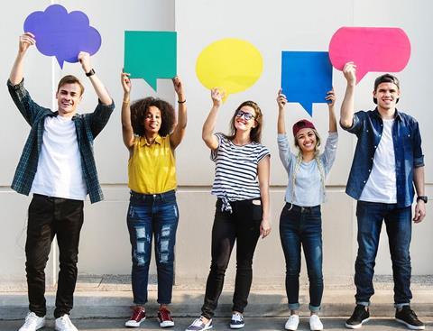 Group of young adults holding cutouts of various speech and thought bubbles