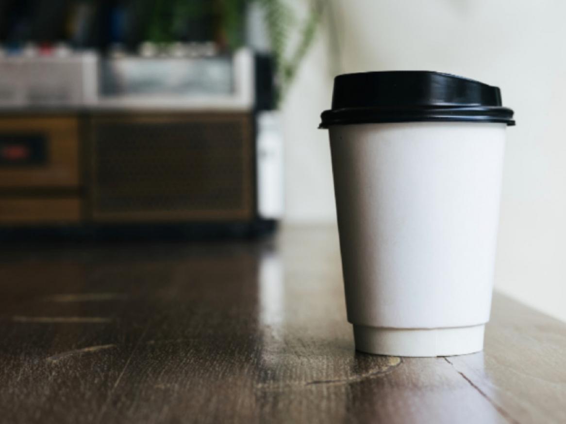 Disposable coffe cup on wooden surface