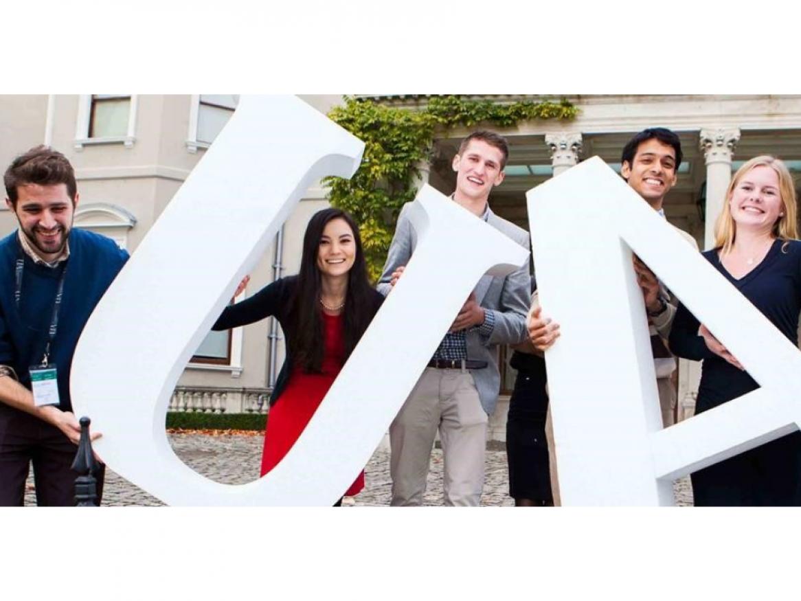 Students attending Undergraduate Award, holding large white letters U and A