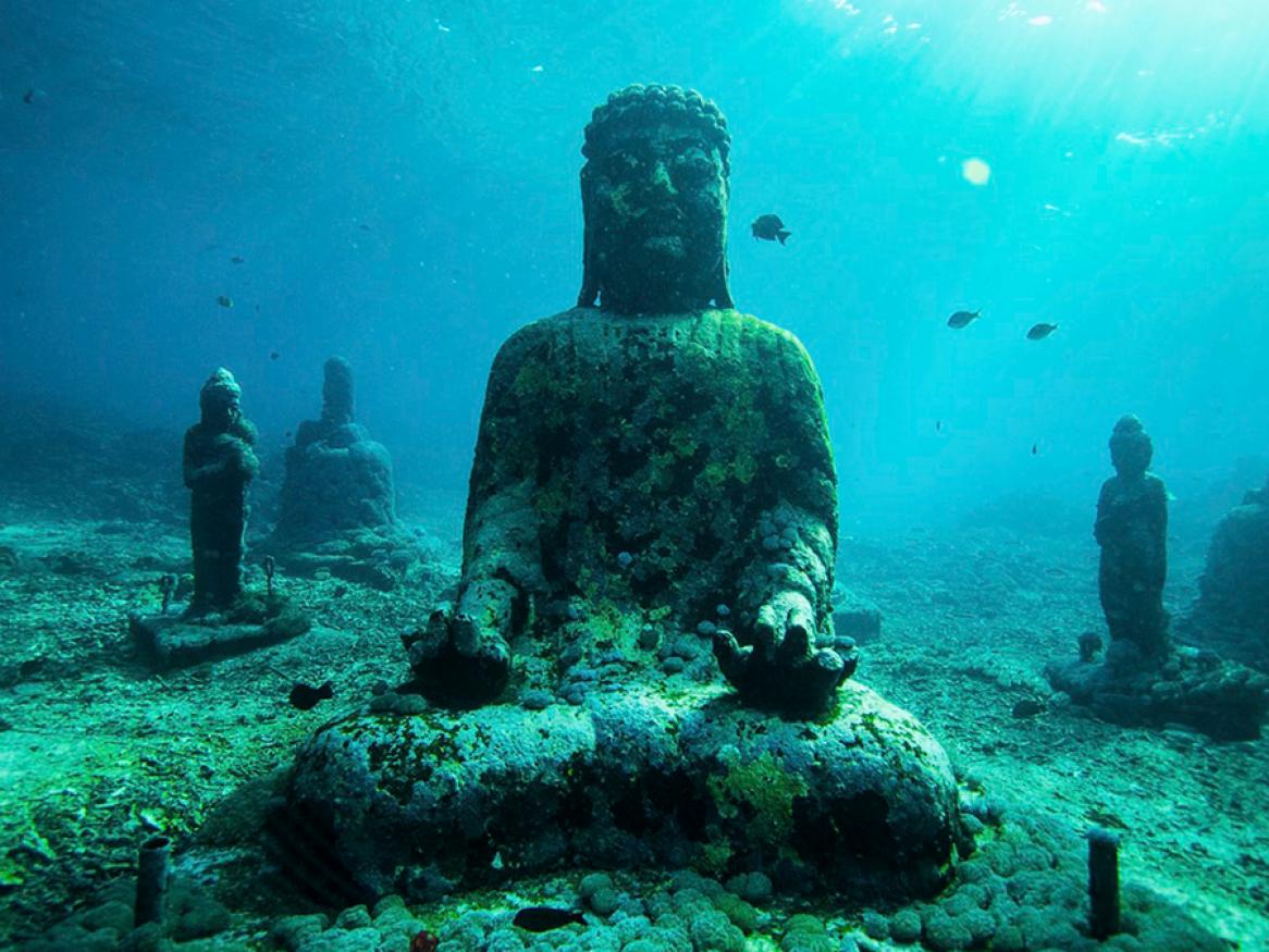 Crumbling underwater statue of Buddha.
