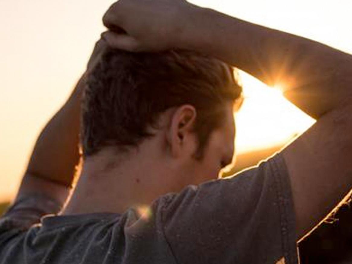 Man standing with hands on head, appearing stressed