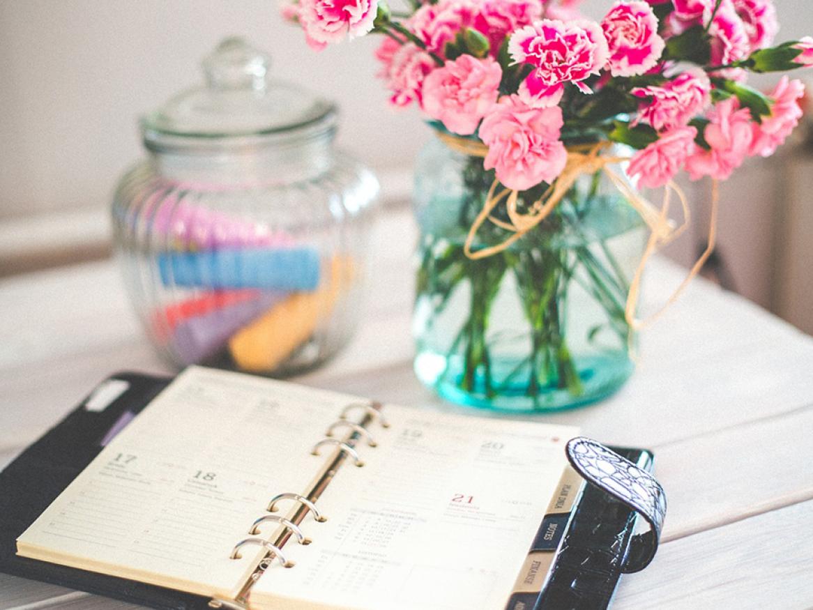 Organiser and pink flowers on desk