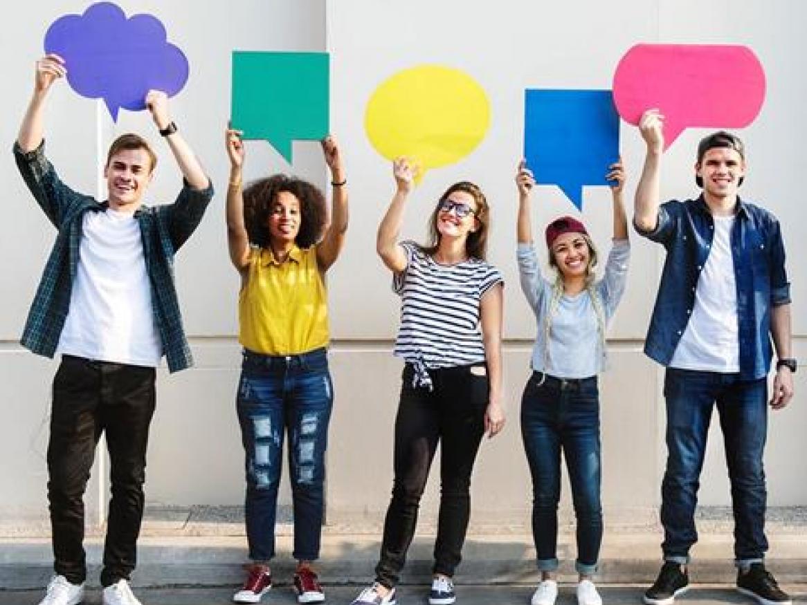 Group of young adults holding cutouts of various speech and thought bubbles