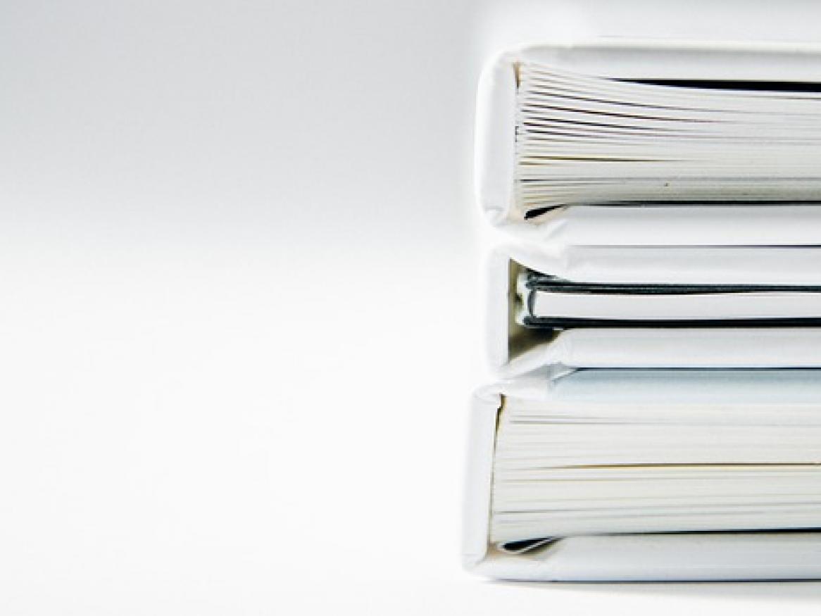 Three white books stacked on top of each other, seen from the bottom