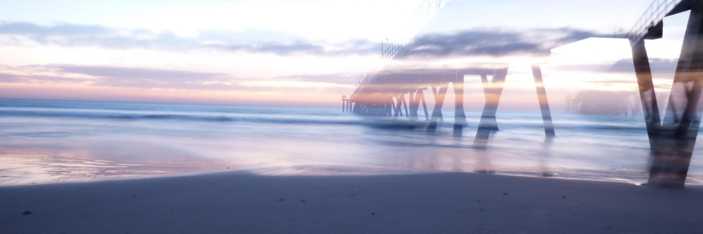 A sunset over a peer at the beach