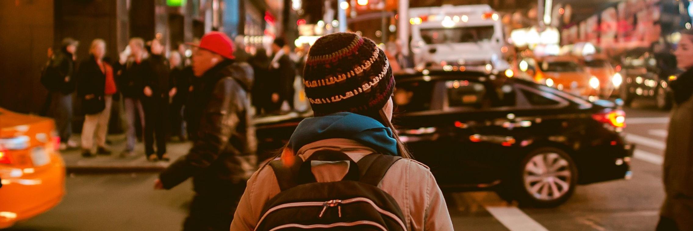 Person walking through bustling city streets.