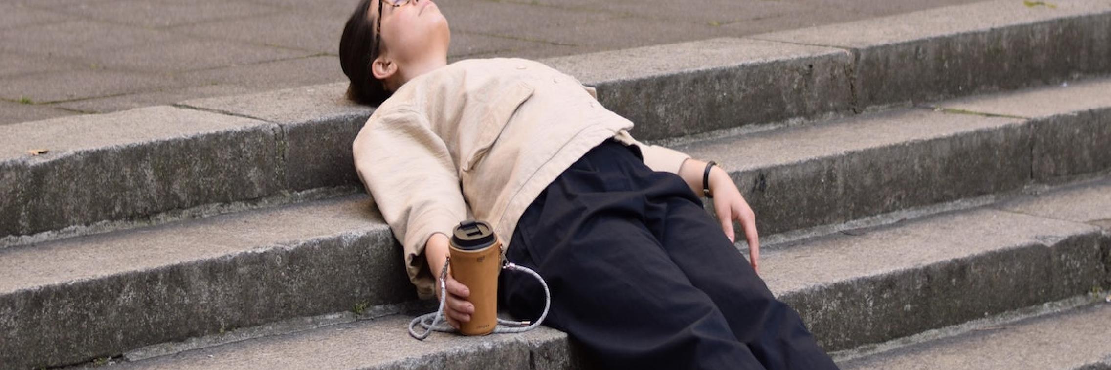 A woman laying on the steps of a building.