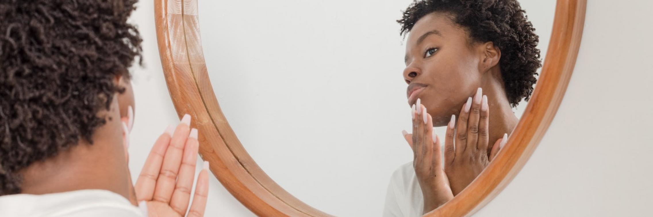 Woman applying skincare product on her face.