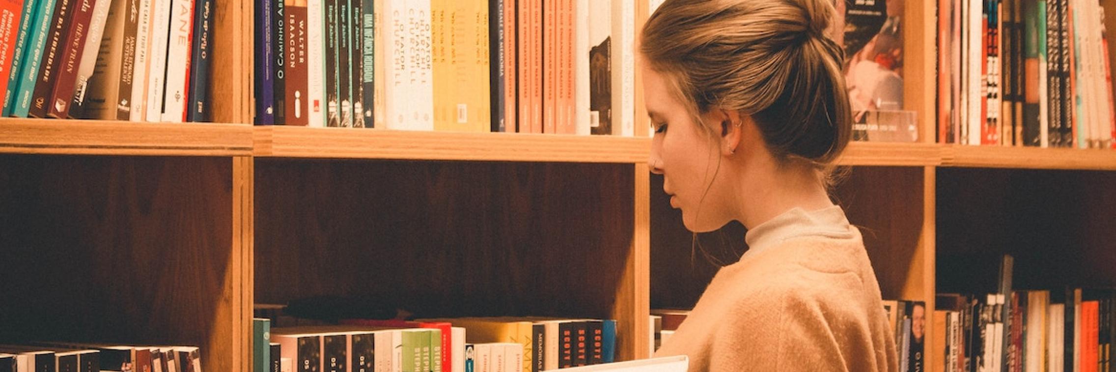 A woman browsing the library shelves.