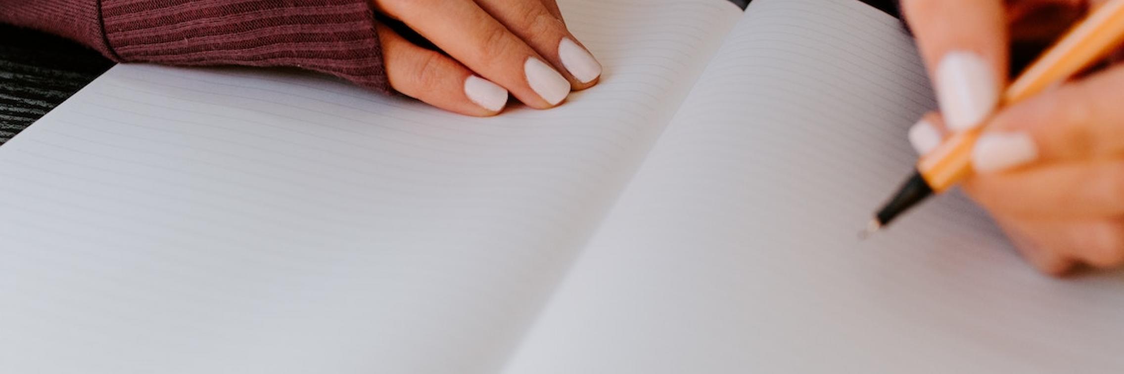 A person writing in a notebook.