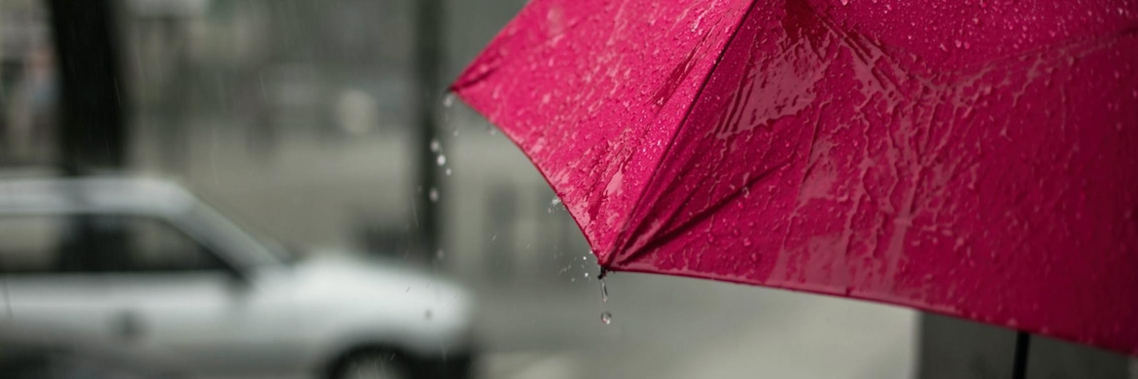 A person holding an umbrella in the rain.