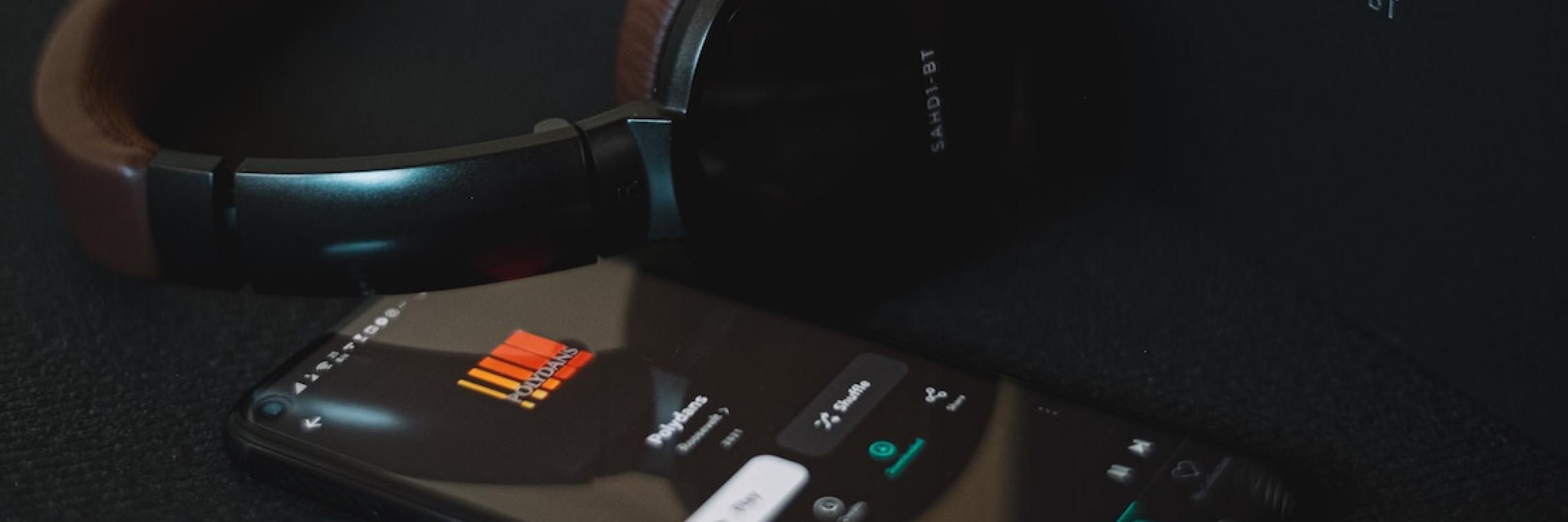 Headphones playing music from a phone.