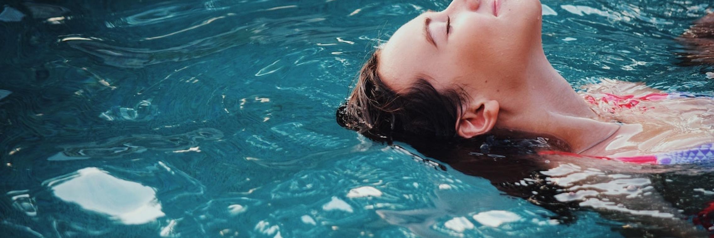 Woman swimming in a body of water.