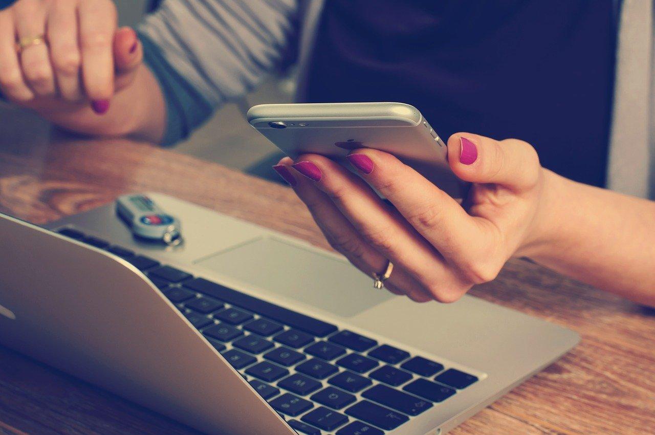 Person with phone and laptop