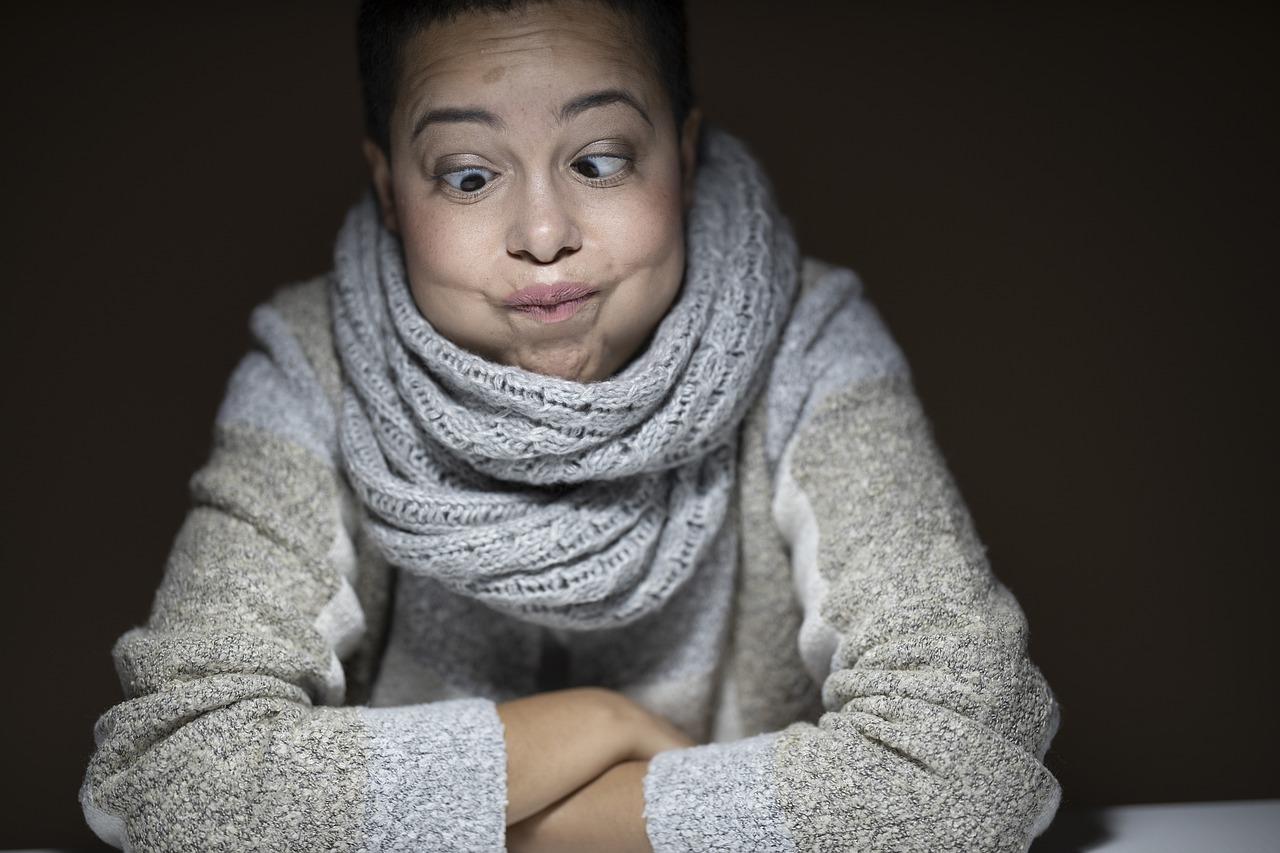 A person crosses their arms and makes a silly face out of boredom