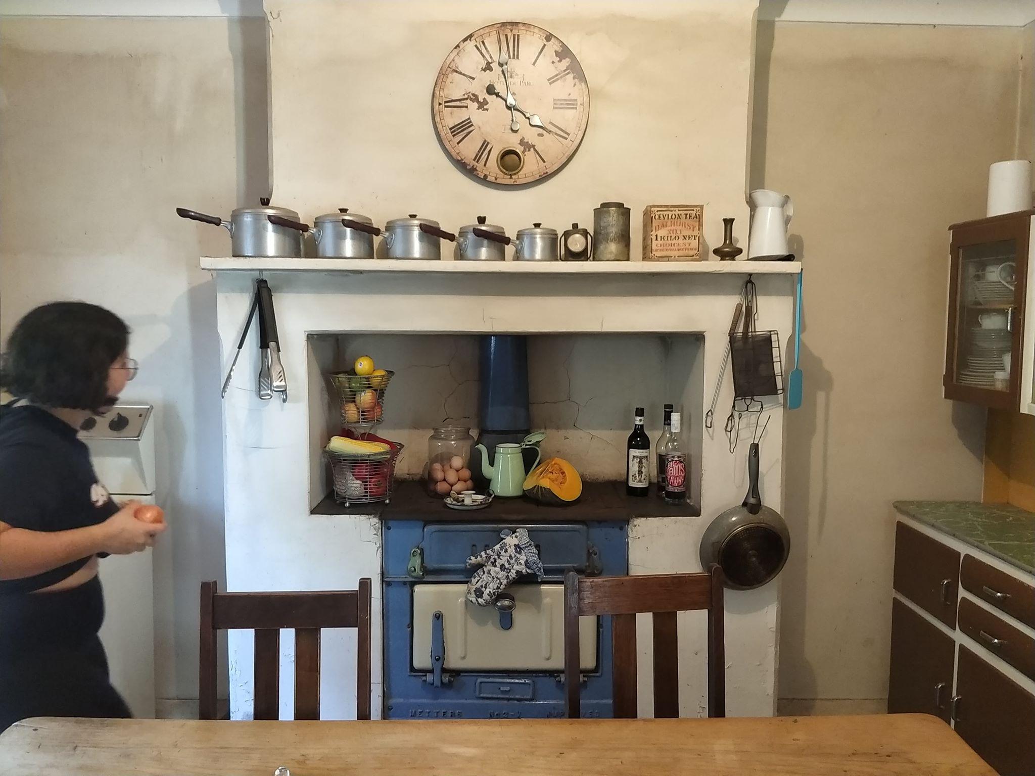 a person stands in an old-fashioned cottage kitchen