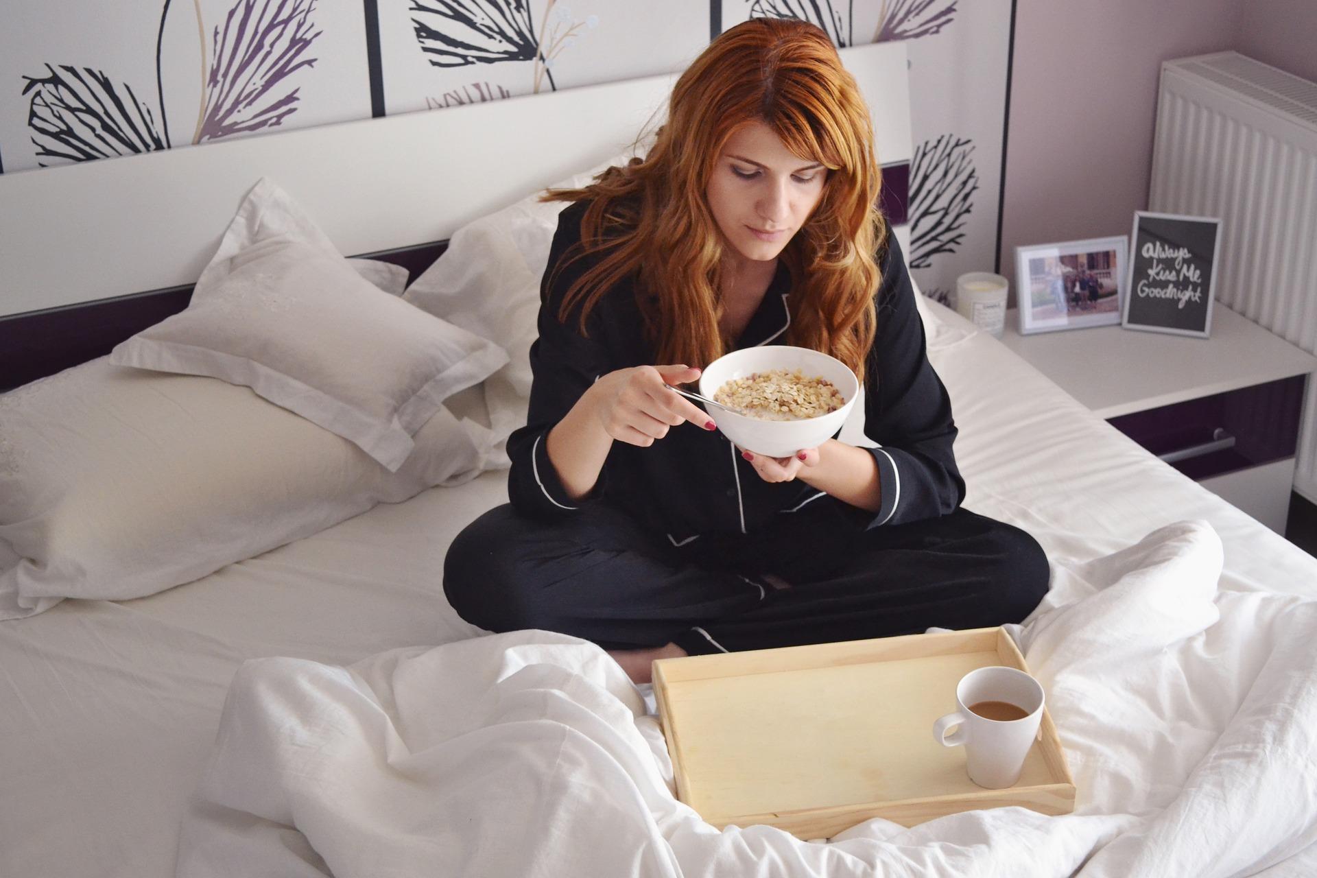 girl in bed eating cereal