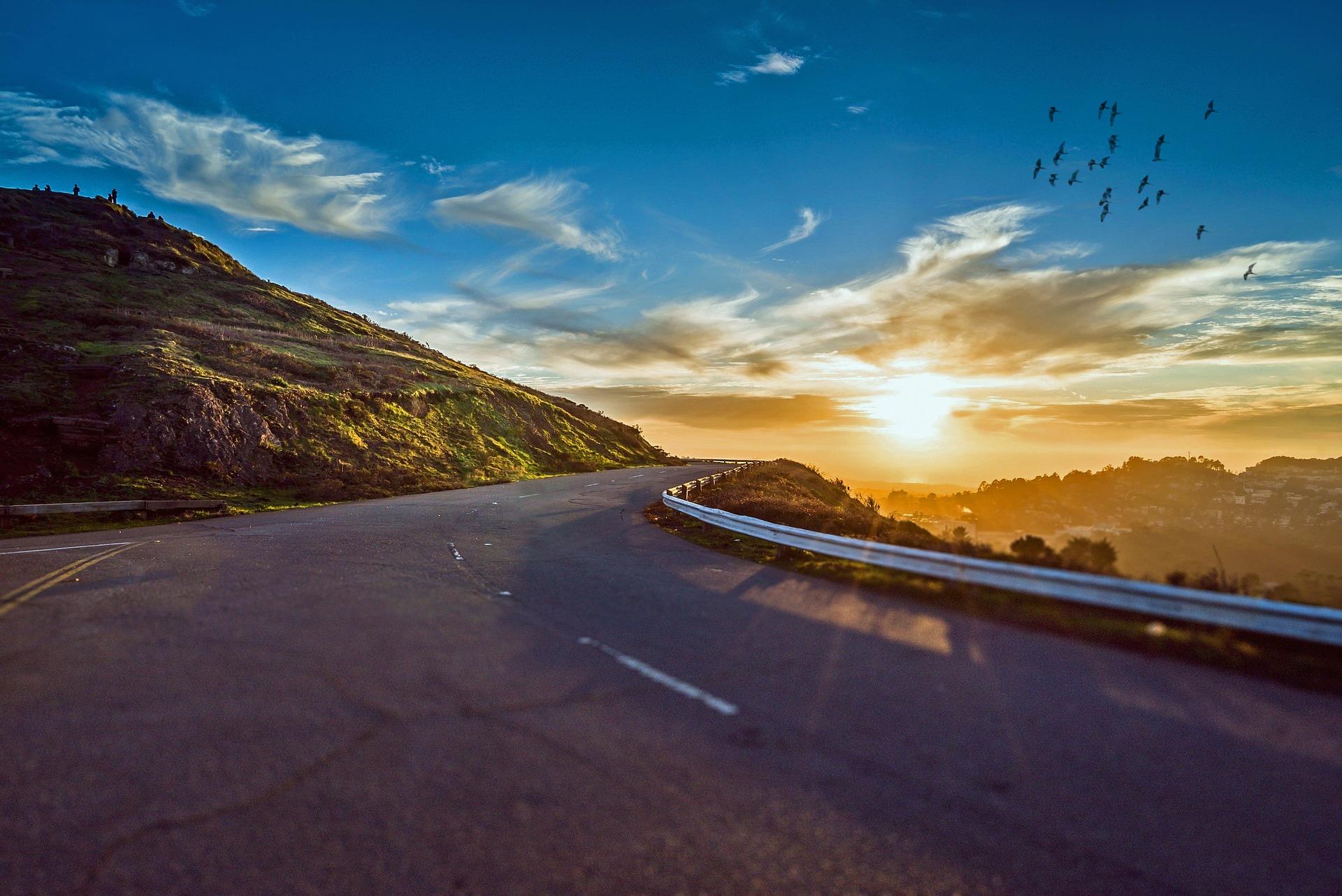 winding road with the sun in the distance