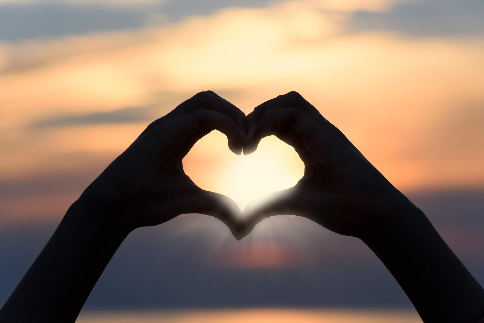 Holding hands up in the shape of a love heart