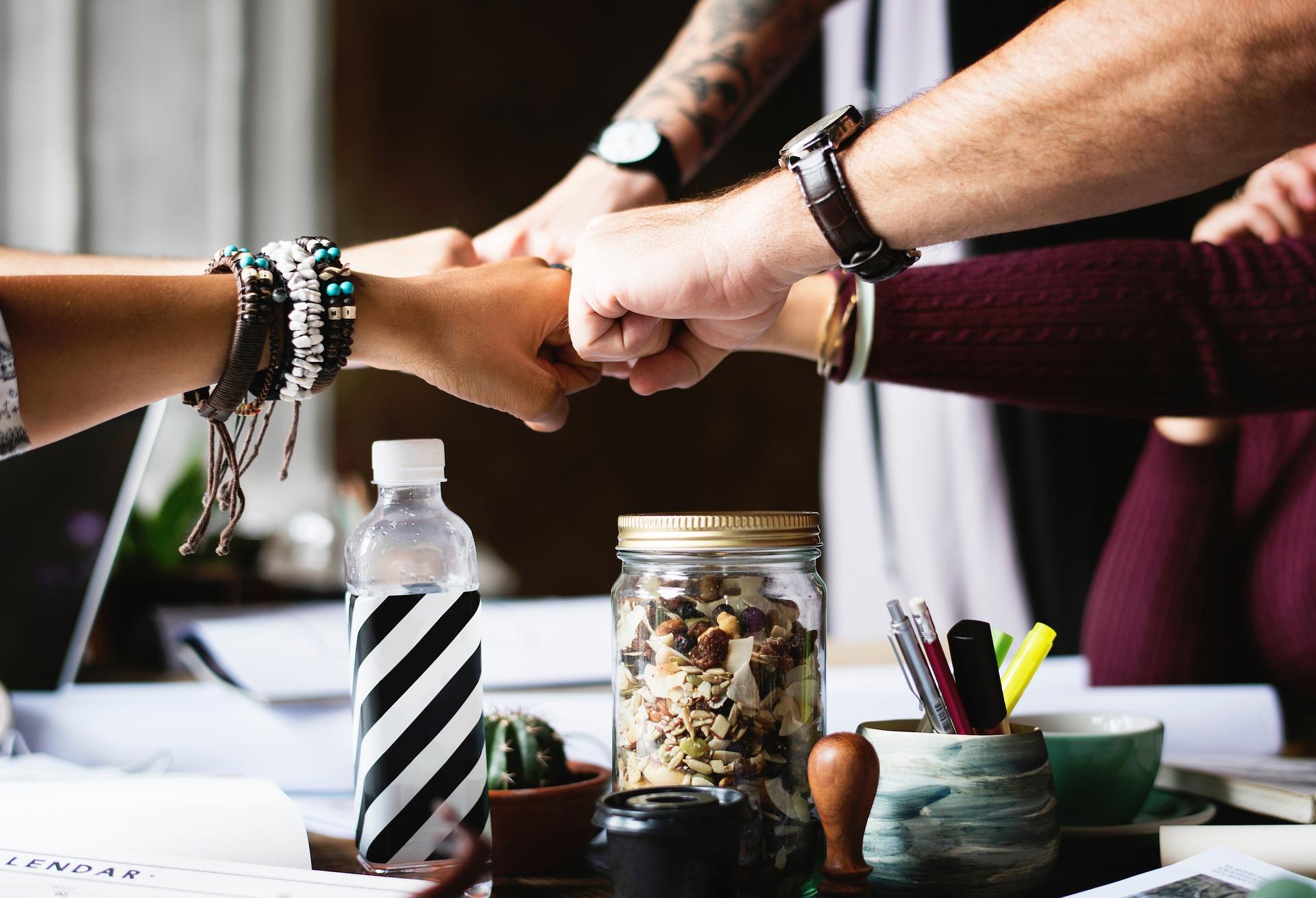 multiple friendly hands meeting at fists