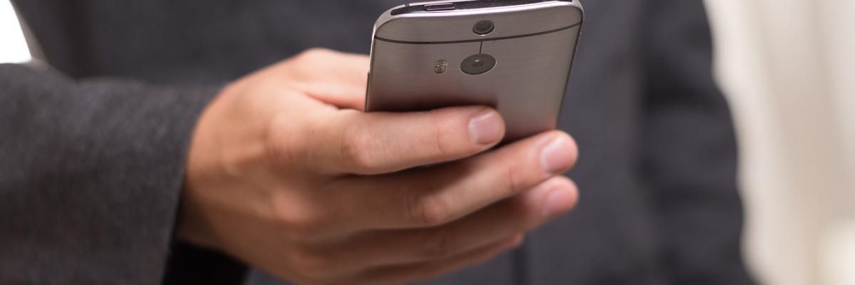 Man holding smartphone out in front of himself.