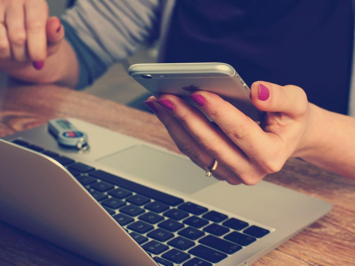 Person with phone and laptop
