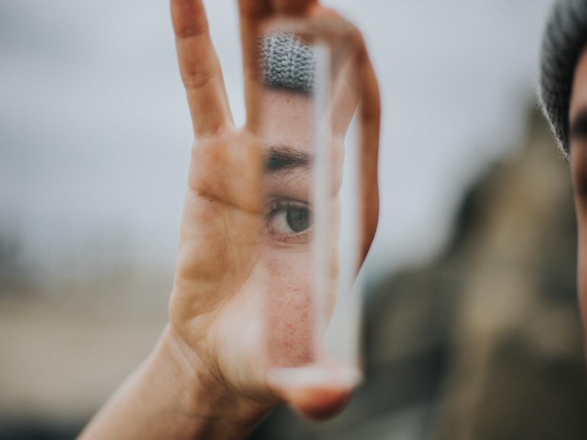 A reflection of someone's eyes on a shard of mirror