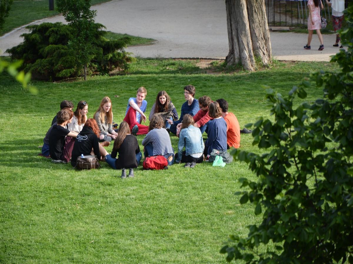 A group of students sitting together on the lawn.