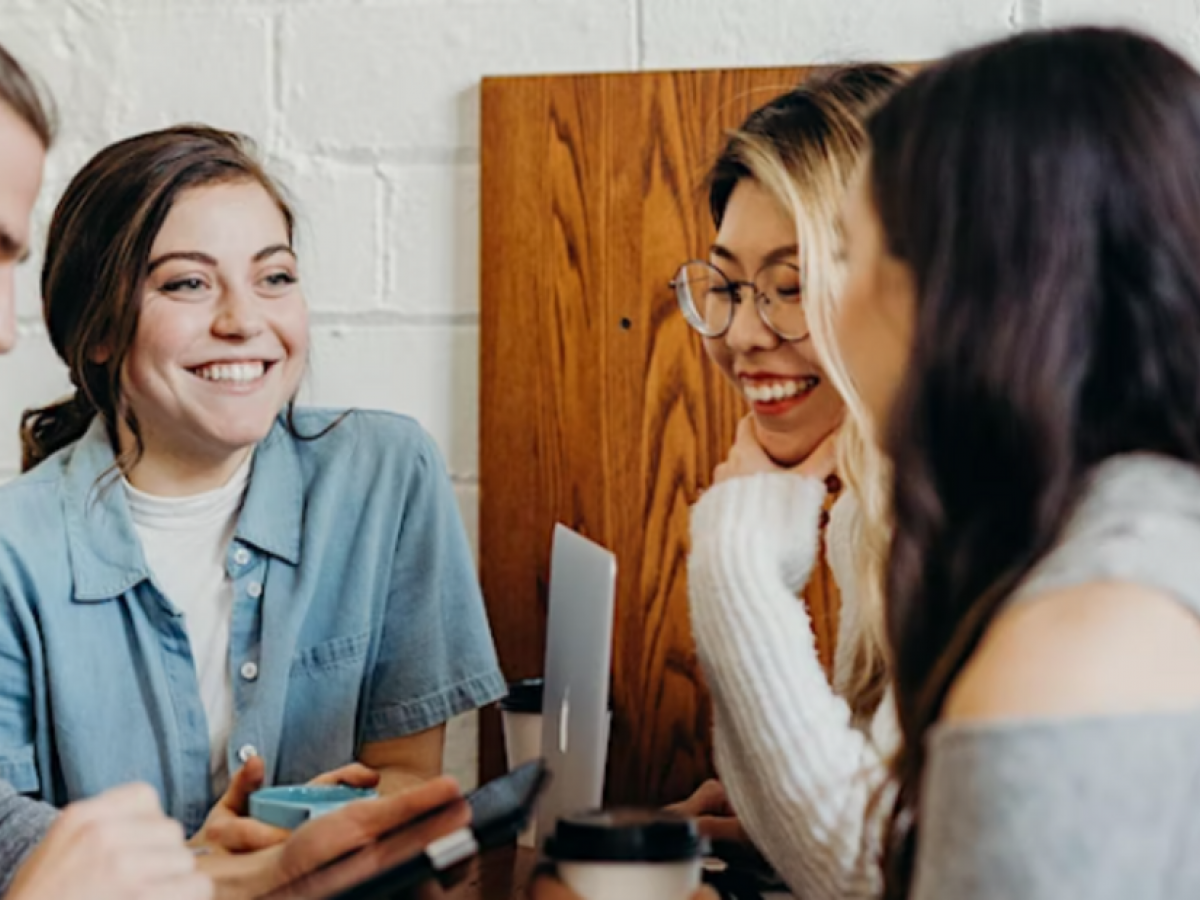 Photo of 4 people sitting talking and laughing