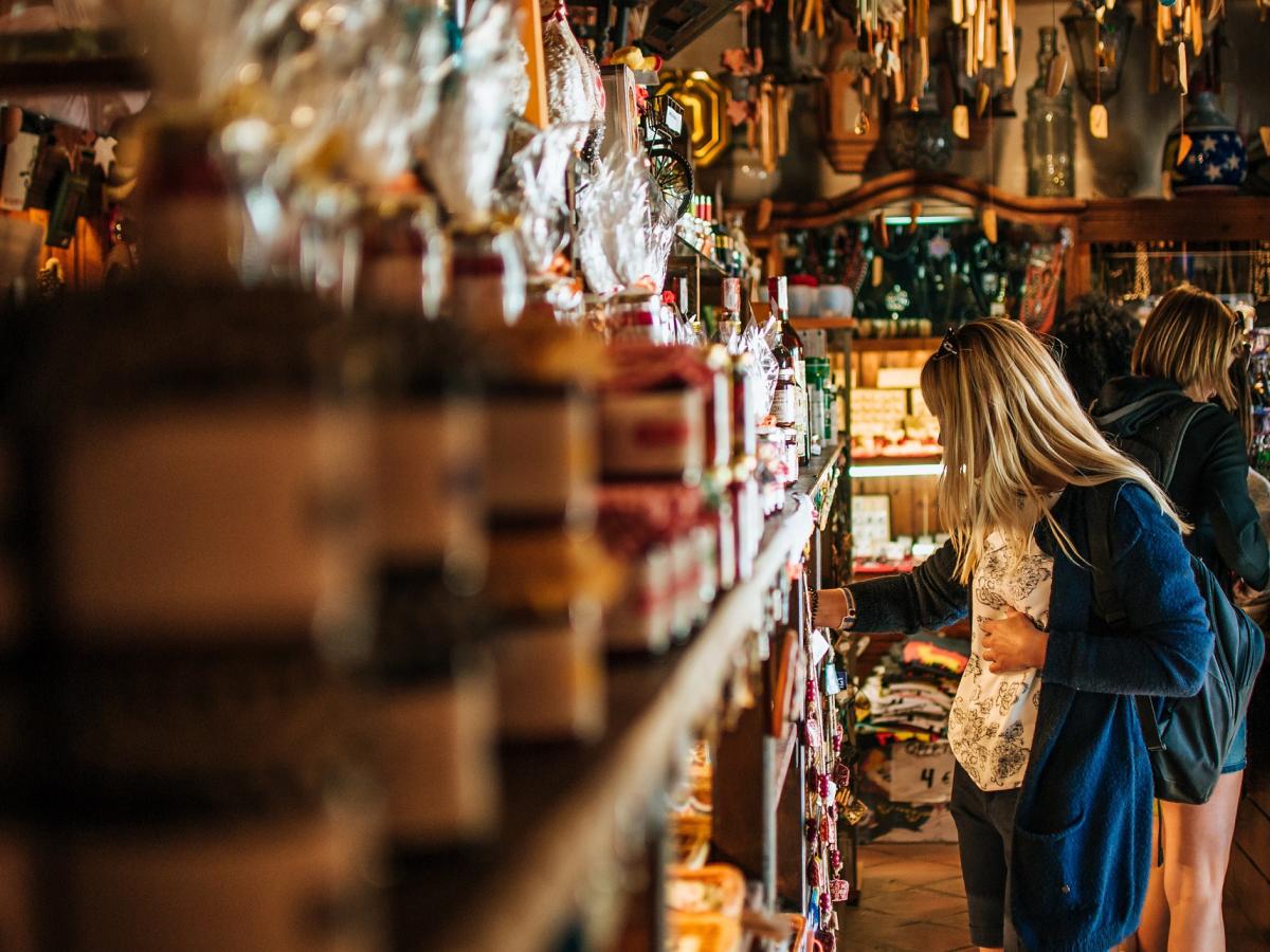 A person in a busy shop looking at items on the shelf.