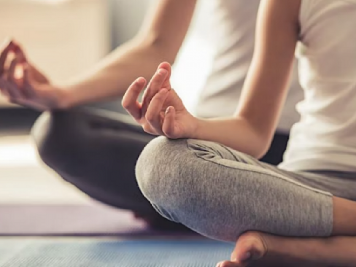 2 people sitting in yoga position pressing fingers against thumbs
