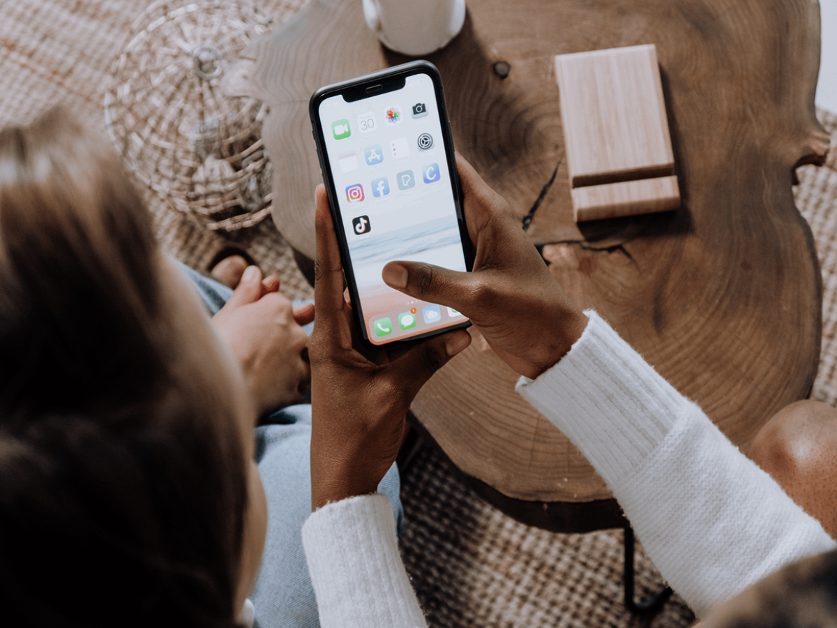 A woman scrolling through the home screen on her phone
