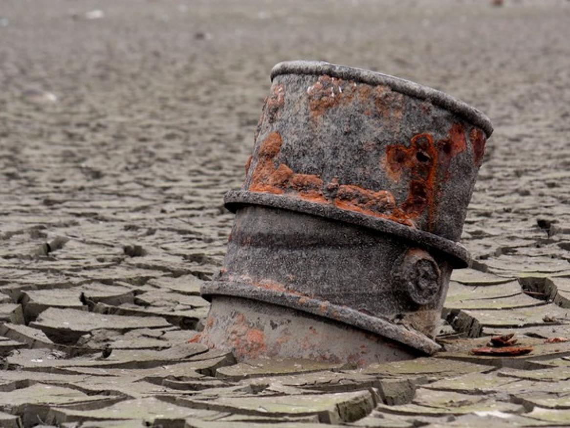 oil barrel buried in desert