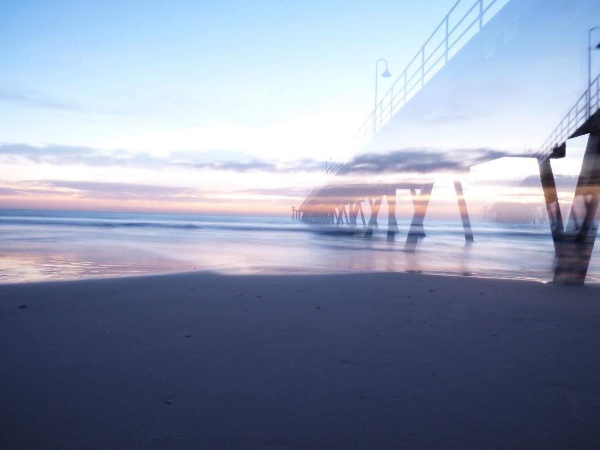 A sunset over a peer at the beach