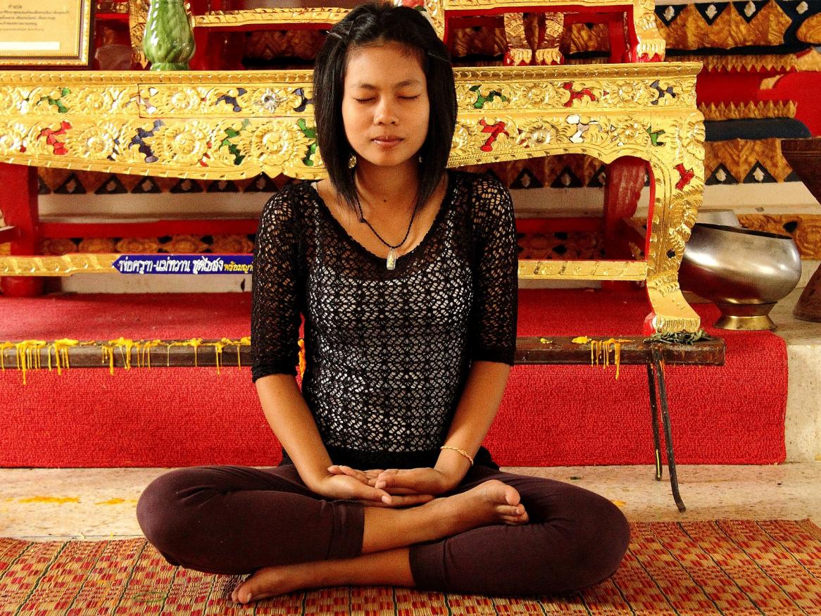 Girl sitting crossed legged and breathing in a relaxed way