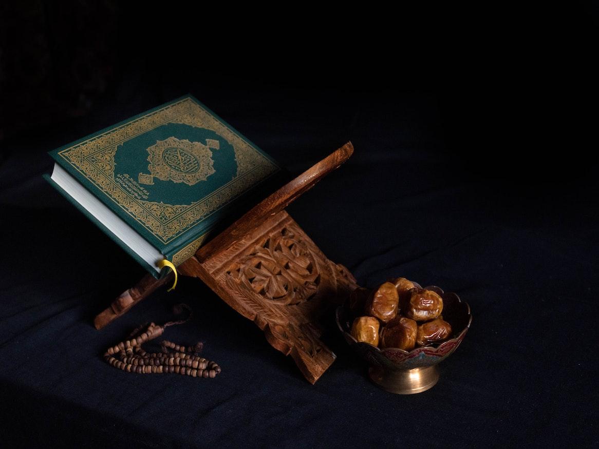 A Quran next to a bowl of dates