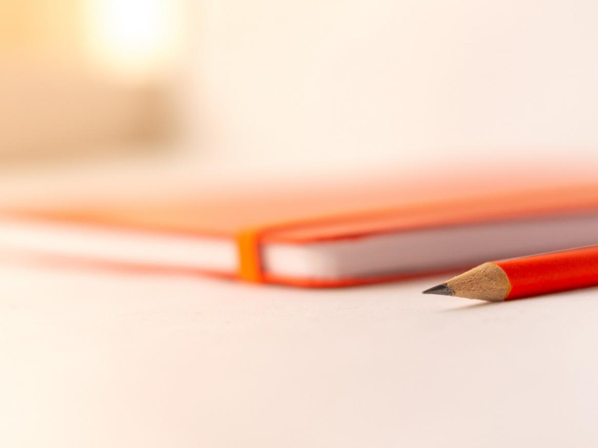 notepad and pencil on a table with blurred background