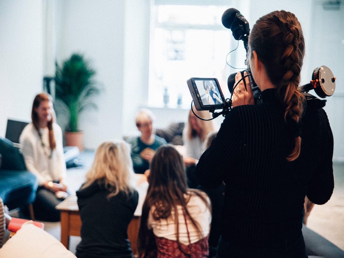 A person filming a group of people.